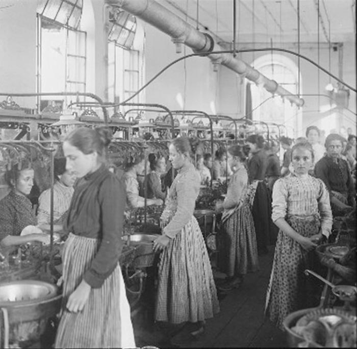 Arbeiterinnen an einer Produktionsstraße in einer Fabrik